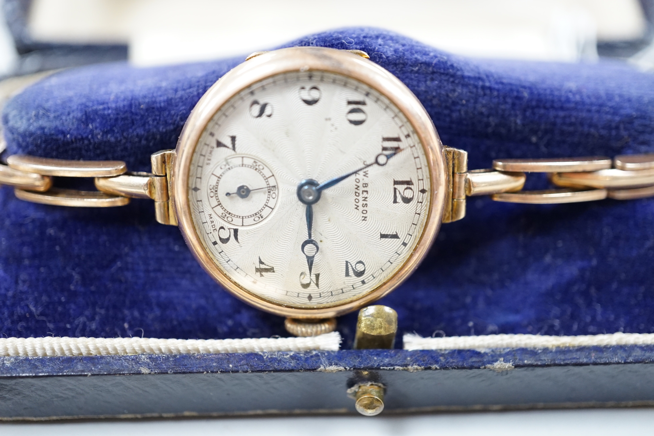 A lady's 1930's 9k J.W. Benson manual wind wrist watch, on a 9ct flexible bracelet, one other gentleman's 9ct gold wrist watch and four other wrist watches.